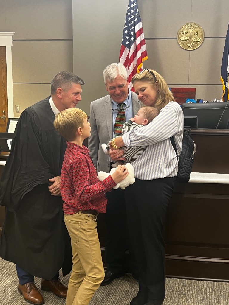 Judge talking with a young boy during adoption proceedings
